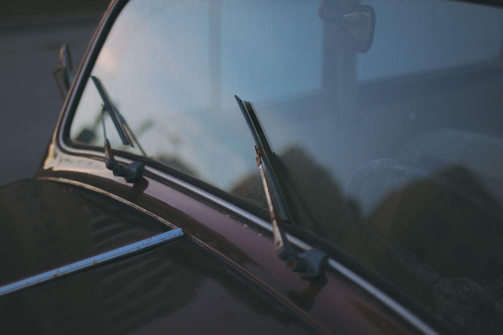 Close-up of a vintage car windshield and its wipers